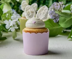 Decorative Easter-themed lemon cupcakes with buttercream frosting and coconut-dipped marshmallow bunny ears, showcased in pastel cupcake wrappers, perfect for a festive spring dessert.